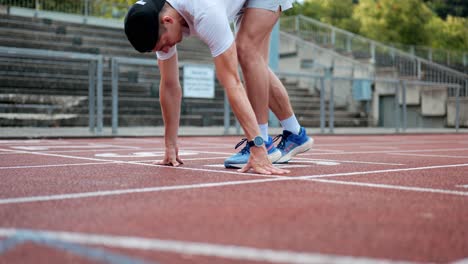 Sporty-male-runner-prepares-for-his-training-at-start-position-of-running-track,-Fitness,-line-athlete-getting-ready-for-challenge