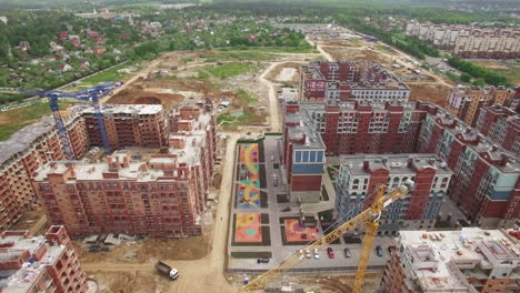 An-aerial-view-of-a-construction-site-of-residential-buildings-in-front-of-the-countryside-scenery