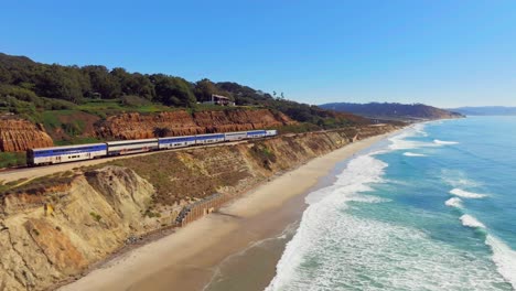 Train-Travels-Along-Bluffs-In-Del-Mar,-San-Diego,-California,-USA---aerial-drone-shot