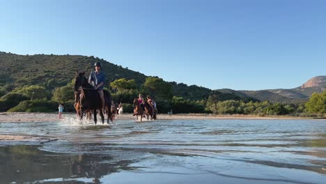 Tourists-ride-horses-in-seawater-in-summer-season