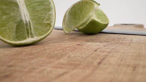 Sliced-limes-on-wooden-board-with-knife