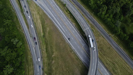 Aerial-view-following-a-semi-truck-driving-on-a-highway,-cloudy-day-in-Canada