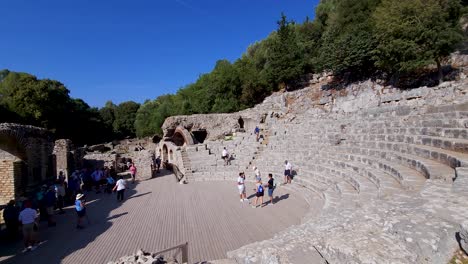Tourists-Marvel-at-the-Stone-Seats-of-the-Ancient-Amphitheater-on-Butrint's-Archaeological-Site,-Steeped-in-History