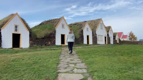 Blonde-woman-visiting-the-Historic-Glaumbær-Turf-Houses-in-north-Iceland