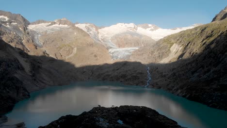 Luftaufnahme-Des-Gletschersees-Des-Gauli-Gletschers-Im-Berner-Oberland-Der-Schweizer-Alpen,-Während-Das-Erste-Licht-Die-Berggipfel-Nach-Sonnenaufgang-Beleuchtet