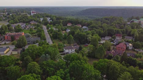 Neighboring-houses-surrounded-by-trees-in-Sigulda-town-in-Latvia,-aerial