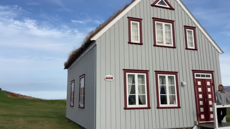 Touristin-Posiert-Vor-Einem-Traditionellen-Isländischen-Haus-Mit-Rasendach-Im-Glaumbaer-Museum