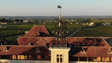 Drone-flying-over-Chateau-Angelus-winery-with-vineyards-in-background,-Saint-Emilion-in-France