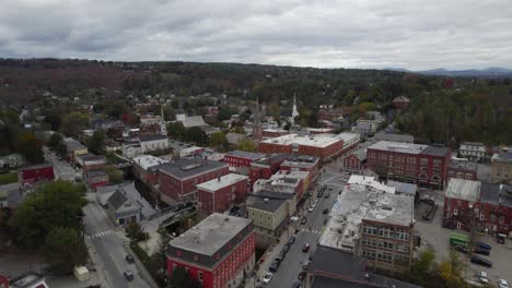 Montpelier-city-red-facade-building-area-near-fall-forest,-overcast-day