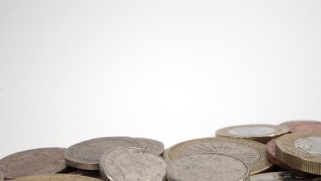Pile-of-British-Coins-in-Soft-Focus,-white-backdrop