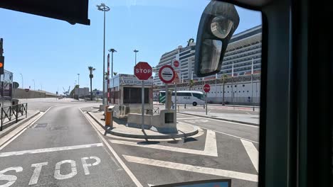 POV-Blick-Auf-Den-Hafen-Des-Jachthafens-Mit-Großem-Schiff-Während-Einer-Stadtrundfahrt-Durch-Die-Stadt-Barcelona-Mit-Dem-Bus,-Spanien
