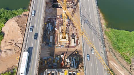 Heavy-traffic-and-construction-crane-for-new-Middle-bridge-in-Kaunas,-aerial-view
