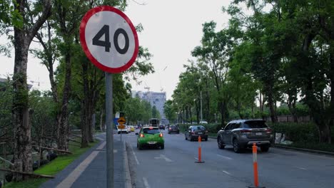 40-Km-Straßenschild,-Ein-Grünes-Auto-Hält-Für-Eine-Weile-Mit-Eingeschalteter-Warnblinkanlage-An,-Während-Andere-Auf-Der-Rechten-Seite-Weiterfahren,-Chaeng-Watthana,-Bangkok,-Thailand