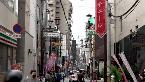 Seitenstraße-Im-Dotonbori-Viertel-In-Osaka-Mit-Menschen-Und-Wenig-Verkehr-Auf-Der-Straße