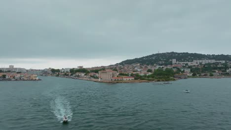 Vista-Aérea-De-Un-Barco-A-Motor-Con-Científicos-Navegando-Fuera-Del-Canal-En-Sète,-Francia.