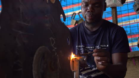 African-Silversmith-Works-Indoors-Melting-Metals-in-his-Repairment-Shop,-Closeup
