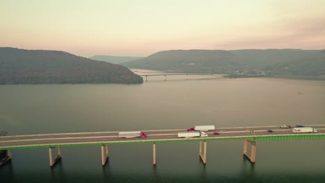 FedEx-LKW-Fahrer-Liefert-Waren-Aus,-Filmische-Luftaufnahme-Der-Tennessee-River-Bridge-Bei-Sonnenuntergang