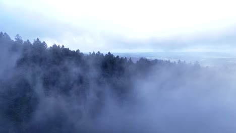 Luftaufnahmen-Mit-Sich-Schnell-Bewegenden-Wolken,-Die-In-4k-Auf-Einen-Bergrücken-über-Dunklem-Wald-Fliegen