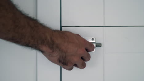 Sicherung-Der-Privatsphäre:-Nahaufnahme-Einer-Hand,-Die-Den-Türriegel-Eines-Modernen-Badezimmers-Betätigt