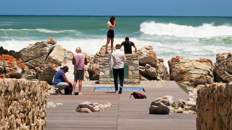 Tourists-posing-at-landmark-in-Agulhas-where-Indian-and-Atlantic-oceans-meet