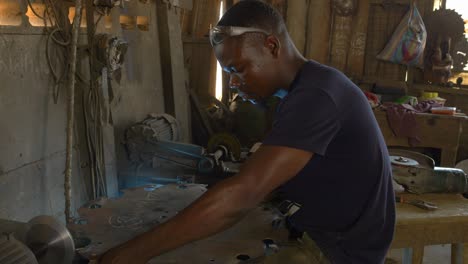 Schwarzafrikanisches-Männliches-Model-Arbeitet-In-Einer-Metallsägenfabrik-Und-Schärft-Werkzeuge
