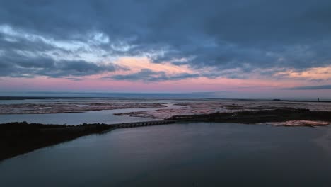 An-aerial-view-over-the-salt-marsh-in-Freeport,-NY-during-a-cloudy-sunset
