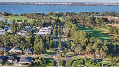 Yarrawonga,-Victoria,-Australia---22-November-2023:-Over-a-farm-and-towards-the-main-gate-at-Silverwoods-Estate-with-houses-and-golf-course