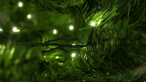 Close-up-christmas-tree-with-decorated-led-lights-glowing,-seasonal-livingroom-decoration
