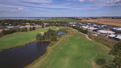 Low-aerial-view-overhead-a-golf-course-and-water-hazards-and-looking-beyond-to-farm-fields-and-Lake-Mulwala