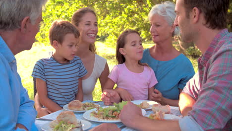 Multi-generation-family-eating-together-outdoors