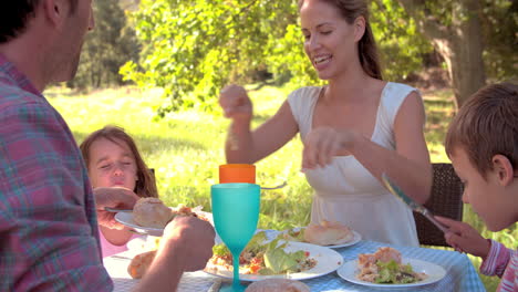Couple-with-two-young-children-eating-together-outdoors