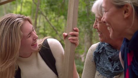 Three-generations-of-woman-laughing-in-a-forest,-slow-motion