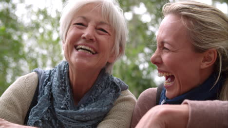 Mother-and-adult-daughter-laughing-outdoors,-slow-motion