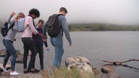 Four-friends-walking-by-the-edge-of-a-lake