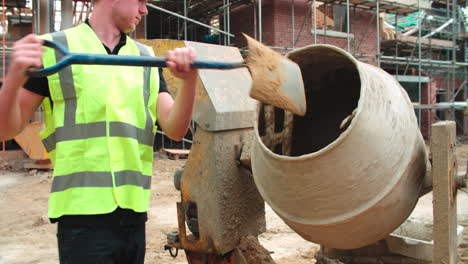 Construction-Worker-On-Building-Site-Mixing-Cement