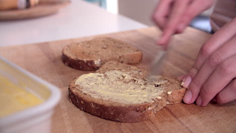 Person-Streicht-Butter-Auf-Eine-Toastscheibe