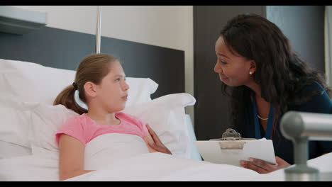 Child-Patient-In-Bed-Talking-To-Doctor-In-Hospital-Room