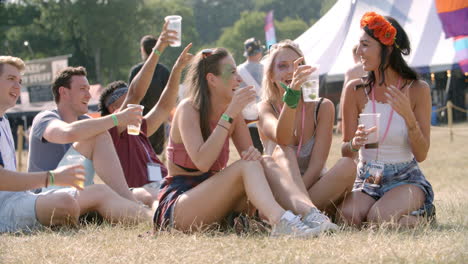 Friends-sitting-on-grass-watching-a-gig-at-a-music-festival