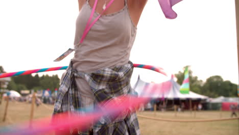 Girl-hula-hooping-at-a-music-festival,-slow-motion