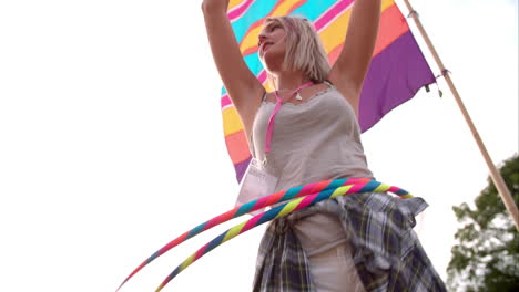 Girl-hula-hooping-with-two-hoops-at-a-festival,-slow-motion