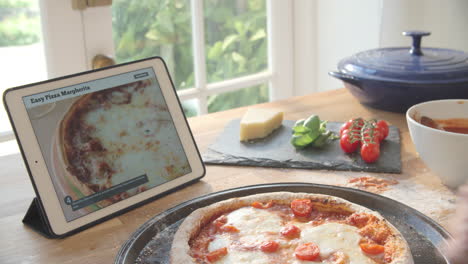 Persona-Siguiendo-La-Receta-De-Pizza-Usando-La-Aplicación-En-Una-Tableta-Digital
