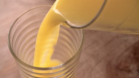 Slow-Motion-Shot-Of-Pouring-Orange-Juice-Into-Glass