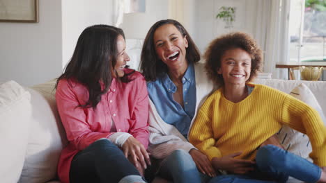 Three-generation-African-American-female-family-group-sitting-on-sofa-laughing-together