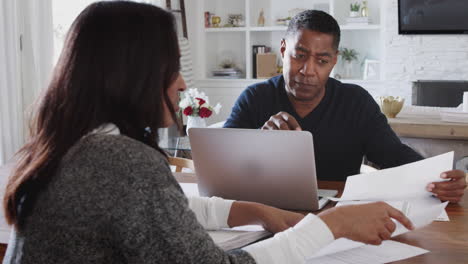 African-American-male-financial-advisor-discussing-documents-with-a-woman-at-her-home,-close-up