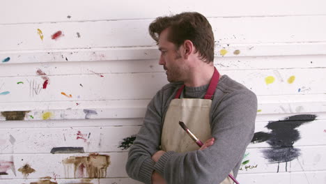 Male-Artist-Leaning-Against-Paint-Covered-Wall-Shot-On-R3D