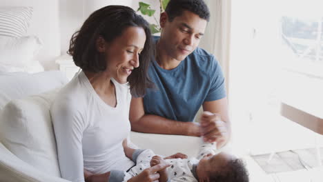 Happy-young-African-American-parents-spending-time-with-their-baby-son,-close-up,-side-view