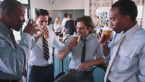 Group-Of-Businessmen-Celebrating-With-Drinks-After-Work-In-Bar