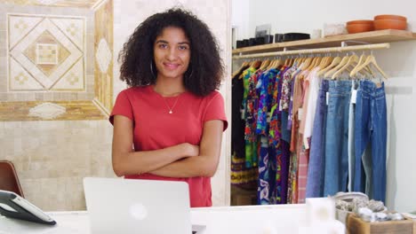 Portrait-Of-Female-Owner-Of-Independent-Clothing-And-Gift-Store-Behind-Sales-Desk