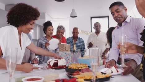 Mutter-Schneidet-Den-Kuchen-An-Und-Serviert-Ihn-Verwandten-Auf-Einer-Geburtstagsfeier-Einer-Schwarzen-Familie-Aus-Drei-Generationen
