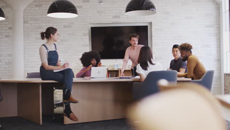 Kreative-Millennial-Mitarbeiter-Diskutieren-In-Einem-Büro-Besprechungsraum,-Rack-Fokus